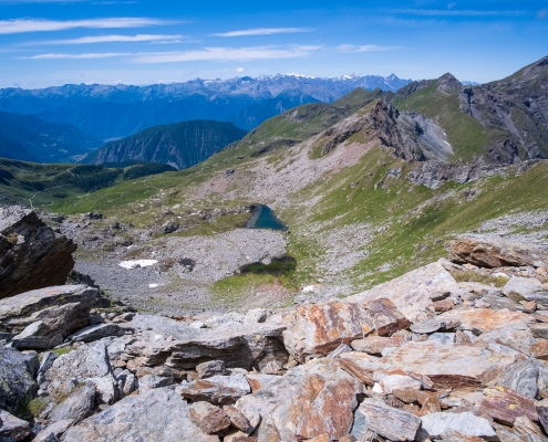 Dal bivio, i Laghi di Valfredda. Sullo sfondo in lontananza il Gran Paradiso, a destra in primo piano il Corno Bussola