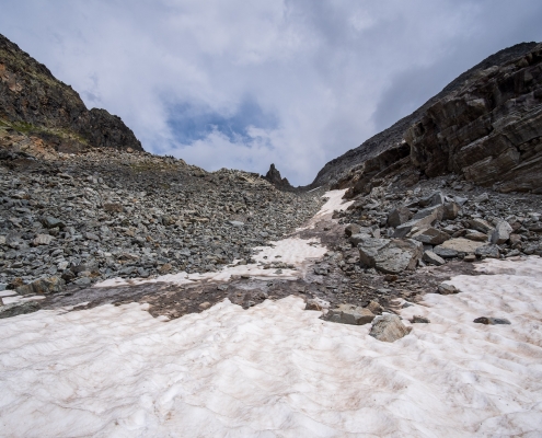 Leave the second snowfield looking for the path in the middle of the scree above