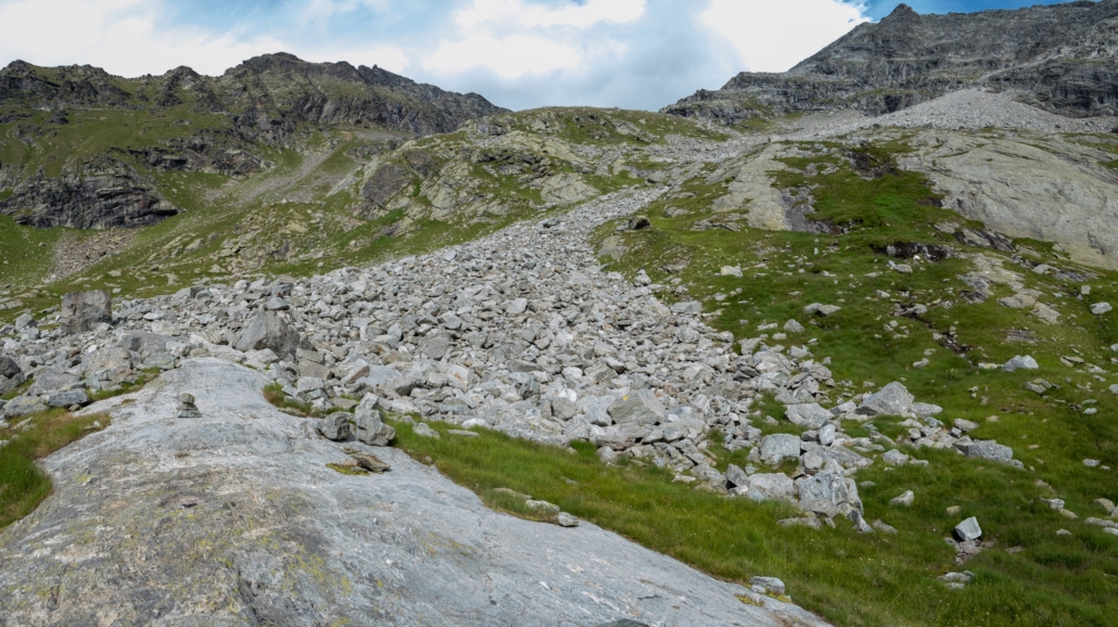 The path climbs to the right of the central hump