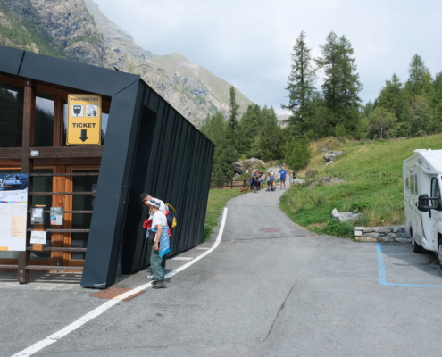 The entrance on the left at the end of the parking lot
